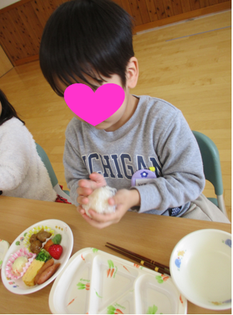 そら組（４歳児）：手の平いっぱいにラップに包んだご飯を乗せ、おむすびを丸めました。