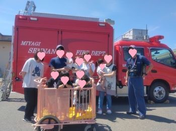 火災の避難訓練に参加しました。消防隊の方と一緒に消防車の前で記念撮影。